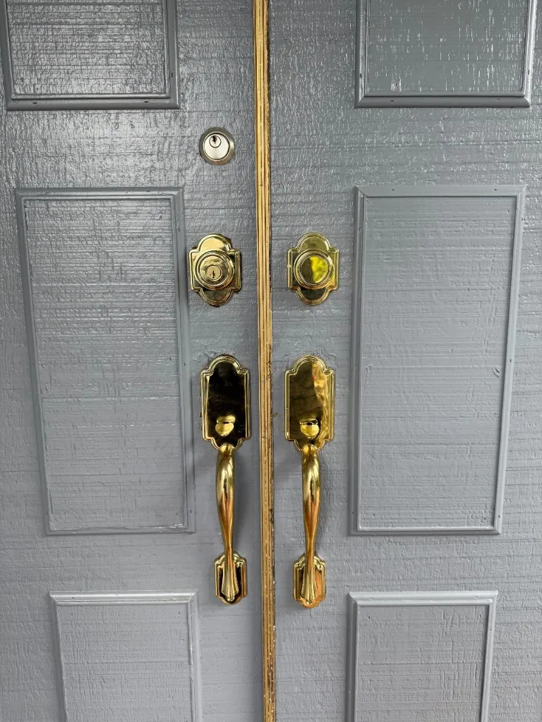 Grey double doors with new polished brass handles and deadbolts